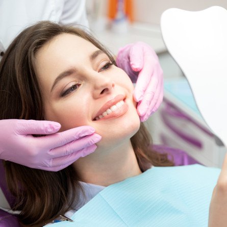 woman smiling in dental mirror