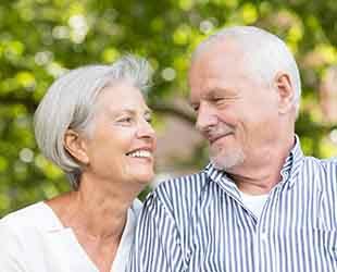 older couple smiling while looking at each other 