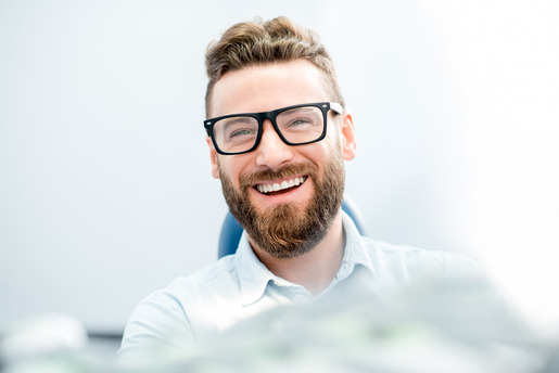 man smiling while visiting cosmetic dentist